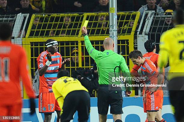 Stephane Mbia of Marseille receives the yellow card after commiting a foul on Sebastian Kehl of Dortmund during the UEFA Champions League group F...