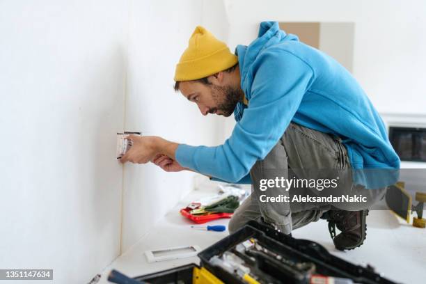 electricista instalando una toma de corriente - toma eléctrica fotografías e imágenes de stock