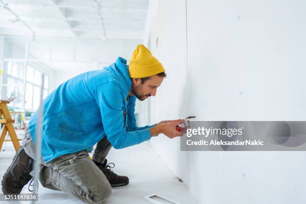 electricista instalando una toma de corriente - toma eléctrica fotografías e imágenes de stock