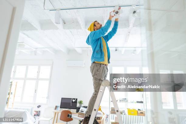electrician fixing ceiling lights - installing ceiling light fixture stock pictures, royalty-free photos & images
