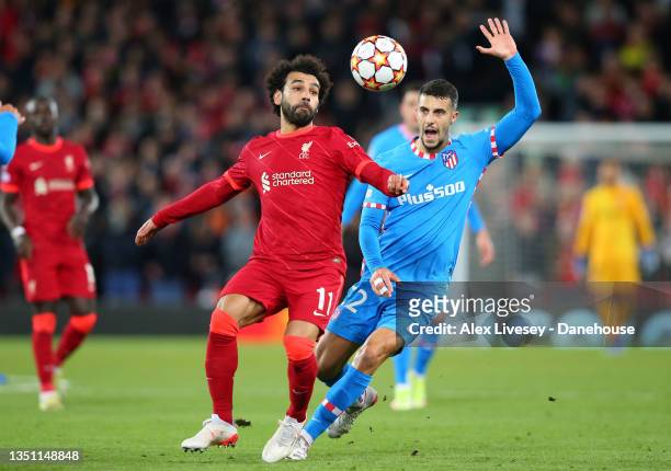Mohamed Salah of Liverpool FC holds off a challenge from Mario Hermoso of Atletico Madrid during the UEFA Champions League group B match between...