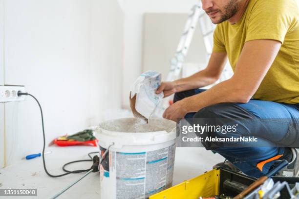 mixing the drywall mud - drywall finishing stock pictures, royalty-free photos & images