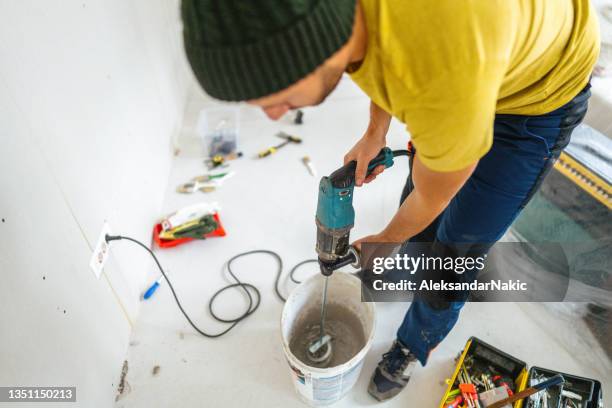 mixing the drywall mud - drywall finishing stock pictures, royalty-free photos & images