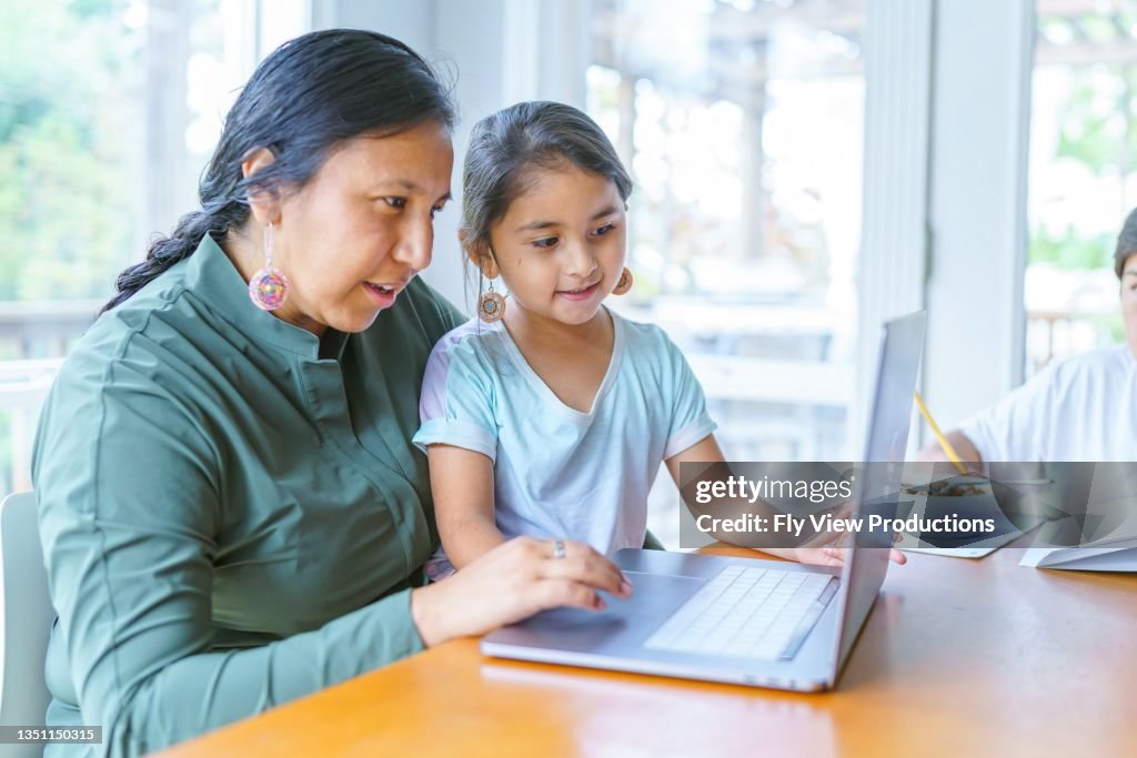Mom working from home with homeschooled children