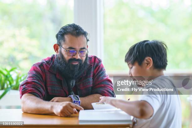 dad helping son with homework - indian bildbanksfoton och bilder