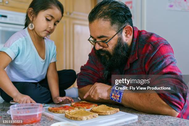 cute little girl helping her dad make sandwiches for lunch - peanut butter and jelly sandwich stock pictures, royalty-free photos & images