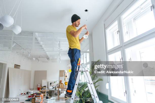 electrician fixing ceiling lights - electrical engineer stock pictures, royalty-free photos & images