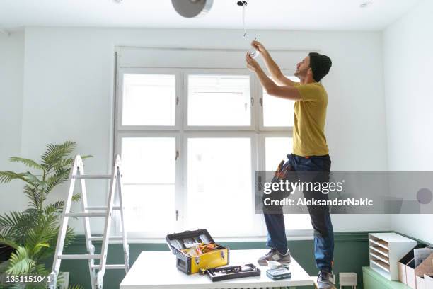 electrician fixing ceiling lights - installing ceiling light fixture stock pictures, royalty-free photos & images