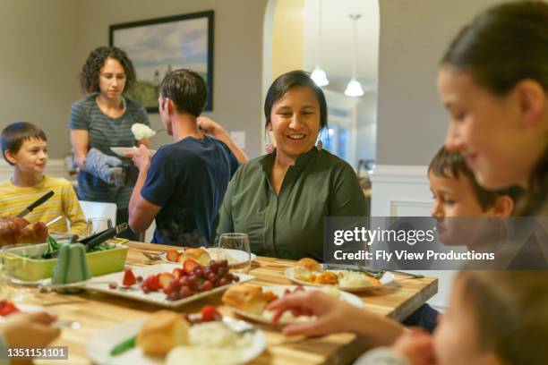 family eating together at holiday table - pacific islander ethnicity stock pictures, royalty-free photos & images