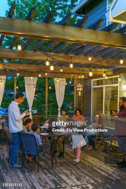 family and friends having dinner party in back yard - family back yard stockfoto's en -beelden