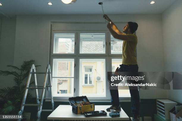 electrician fixing ceiling lights - installing ceiling light fixture stock pictures, royalty-free photos & images