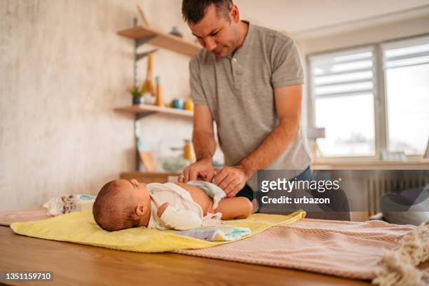 padre cambiando el pañal de su bebé - diaper fotografías e imágenes de stock