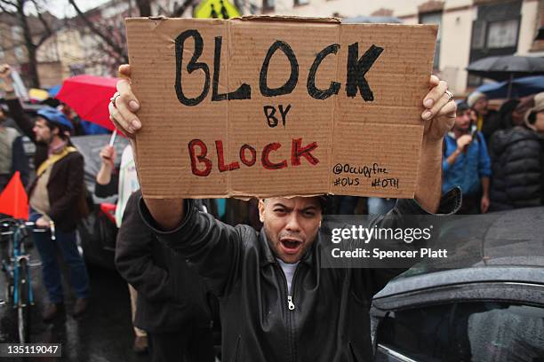 Community activists and over two hundred members of the Occupy Wall Street movement rally around a forclosed home during a march in the impoverished...