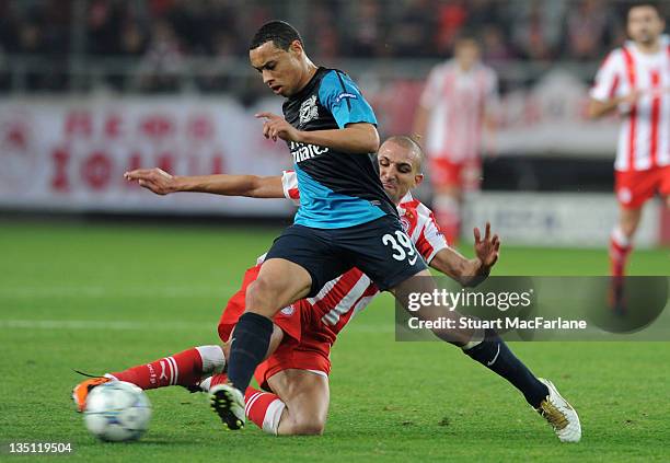 Francis Coquelin of Arsenal is tackled by Rafik Djebbour of Olympiacos during the UEFA Champions League Group F match between Olympiacos FC and...