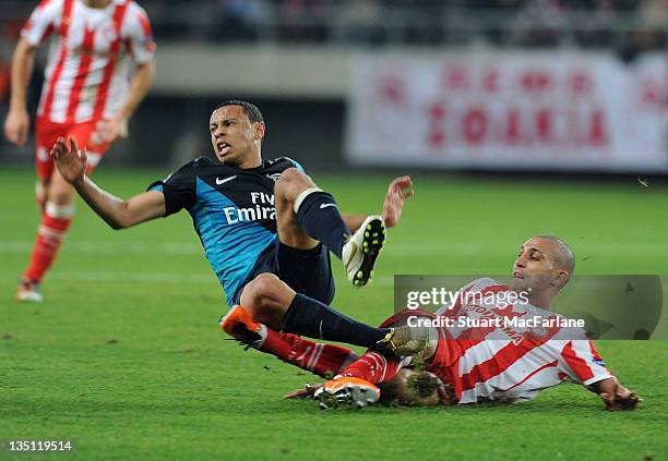 Francis Coquelin of Arsenal is tackled by Rafik Djebbour of Olympiacos during the UEFA Champions League Group F match between Olympiacos FC and...