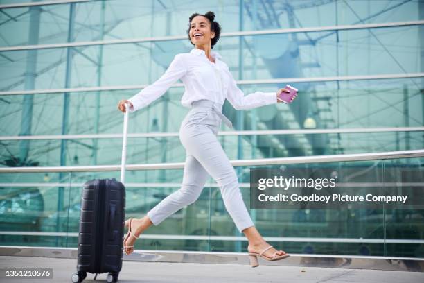smiling businesswoman with a passport and suitcase running to departures - business woman suitcase stockfoto's en -beelden