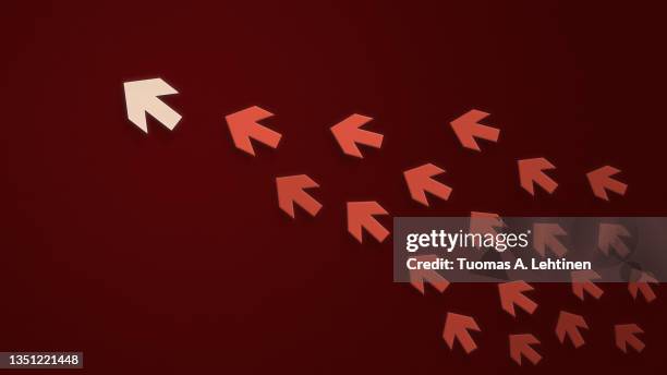 group of red arrows following the leader, white arrow, on a textured dark red paper background. - following arrows stock pictures, royalty-free photos & images