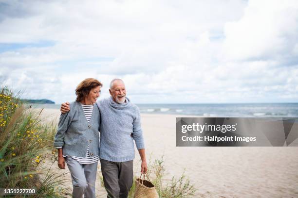 senior couple in love on walk on beach. - strand paar stockfoto's en -beelden