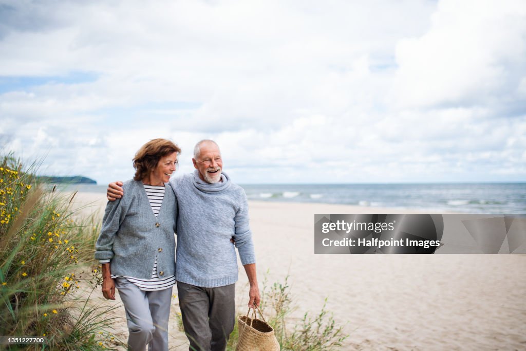 Senior couple in love on walk on beach.