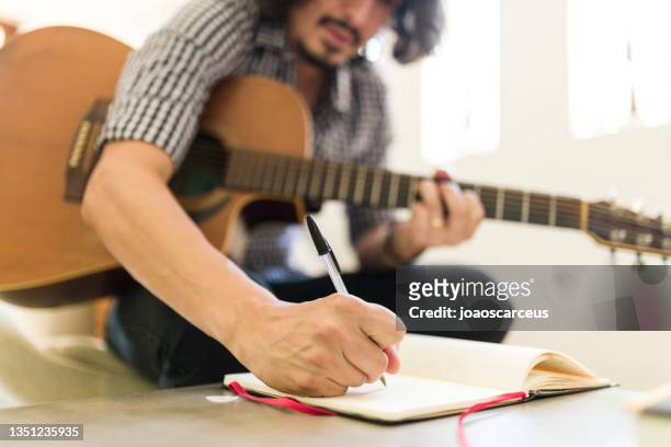 man playing guitar and composing - song writer stock pictures, royalty-free photos & images