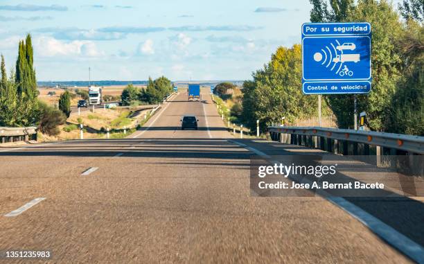 radar speed control warning traffic signal on a highway, point of view from inside the car. - lasergun stockfoto's en -beelden