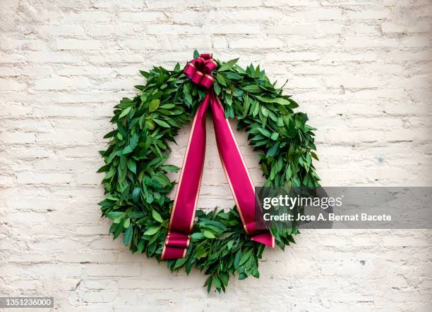 laurel wreath hung on a brick wall outdoors. - bay tree stock pictures, royalty-free photos & images