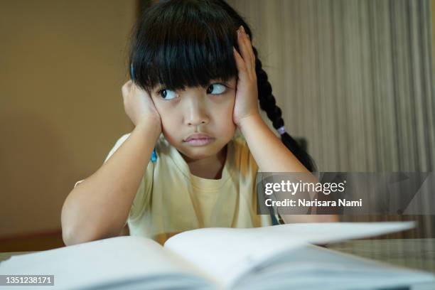 asian child girl is lazy to read the book. education concept. - failure analysis stock pictures, royalty-free photos & images