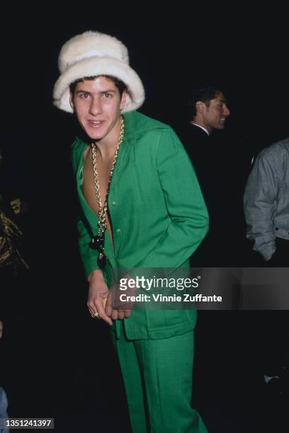 American rapper and musician Michael 'Mike D' Diamond, of Beastie Boys, wearing a green suit and a white fleece hat, attends Sandy Gallin's Christmas...