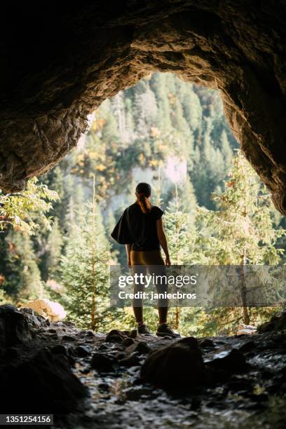 woman exploring mountain cave - speleology stock pictures, royalty-free photos & images