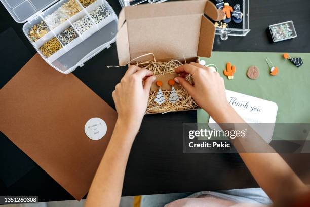 young unrecognisable woman preparing her earrings for delivery - clay earring stock pictures, royalty-free photos & images