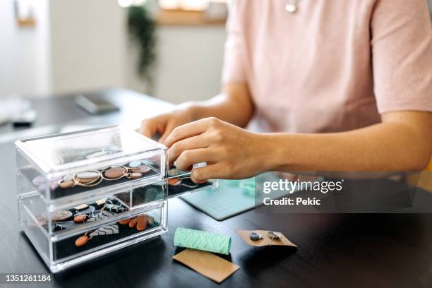 unrecognisable woman checking on her earring design - clay earring stock pictures, royalty-free photos & images