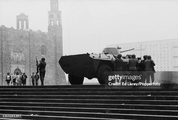 Members of the Mexican Armed Forces take cover behind a MAC-1 armored reconnaissance vehicle during disturbances between unarmed student protesters...