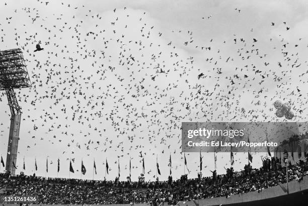 Flock of birds are released to fly above spectators in the stadium during the 1968 Summer Olympics opening ceremony inside the Estadio Olimpico...