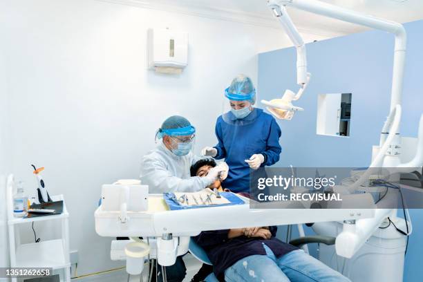 dentist with female assistant treating patient - tres personas 個照片及圖片檔