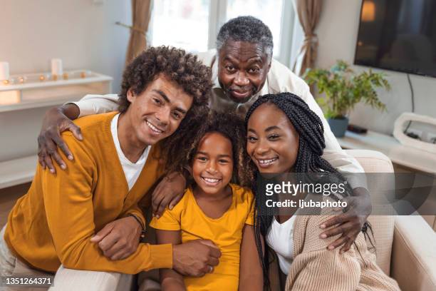 mehrgenerationen-familiengruppe sitzt drinnen auf dem sofa - afro amerikanische kultur stock-fotos und bilder