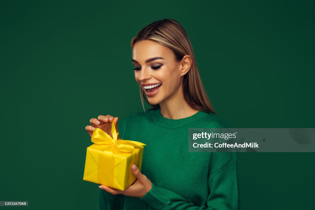 Beautiful emotional woman holding a gift box