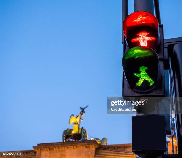 two icons of berlin. ampelman and brandenburger tor. - ampelmännchen stockfoto's en -beelden