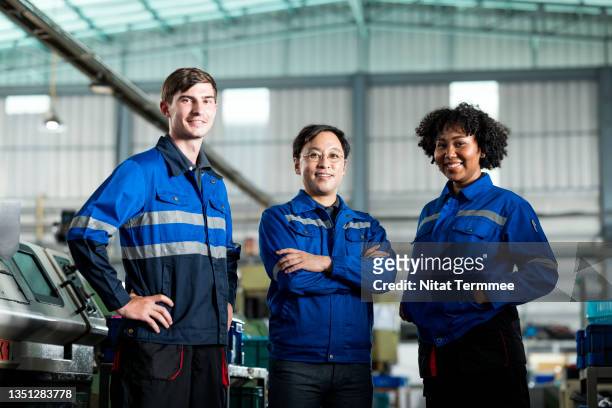improve manufacturing with a team approach. a multiracial group of engineers is working in an engineering parts manufacturing industry and having skilled in production control, quality control, machine maintenance, warehouse, and safety in the workplace. - diversity people industry stock-fotos und bilder