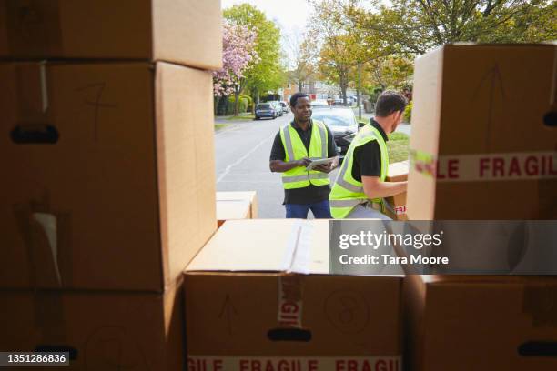 two removal men carrying boxes. - carrying sign ストックフォトと画像