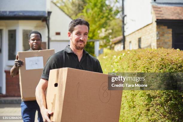 two removal men carrying boxes. - removal men imagens e fotografias de stock