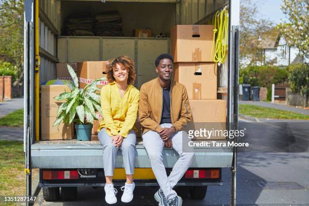 young couple moving house. - man with moving boxes authentic stockfoto's en -beelden