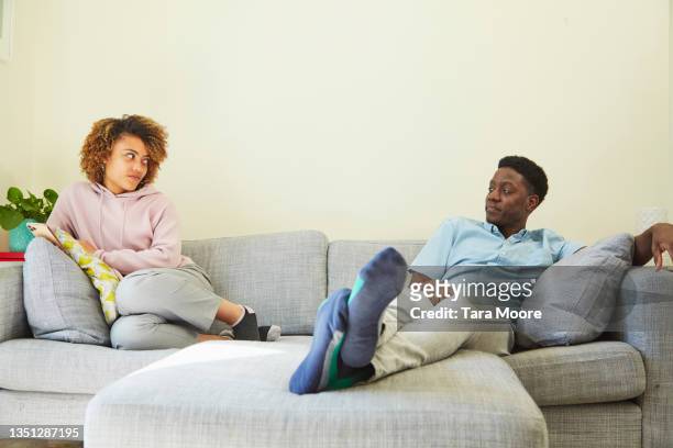 young couple on sofa. - dispute stock pictures, royalty-free photos & images