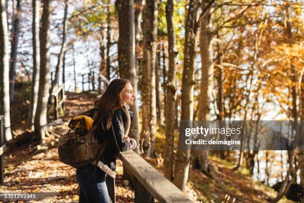 giovane donna escursionista che guarda la foresta autunnale - hiking foto e immagini stock