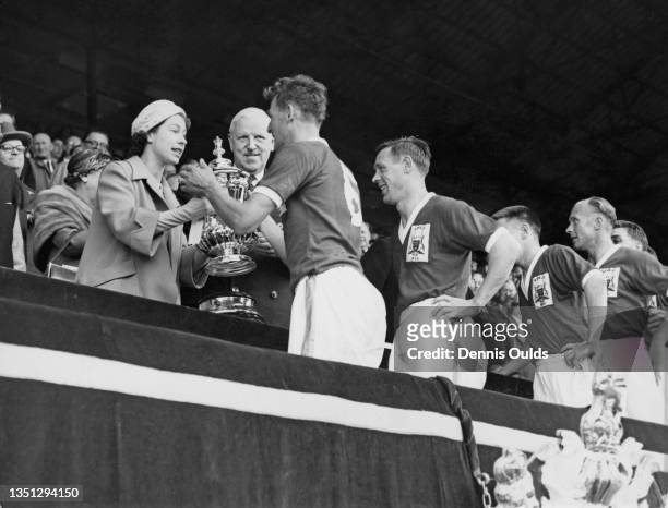 Queen Elizabeth II presents the Football Association trophy to Nottingham Forest Football Club team captain Jack Burkitt after winning the FA Cup...