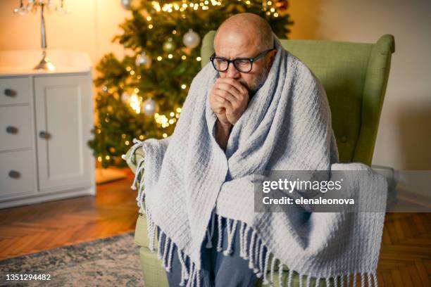 mature adult man in christmas home interior ( in plaid) - frozen man stockfoto's en -beelden