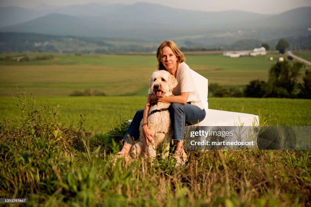 Mujer madura posando con su perro en la frontera entre Canadá y Estados Unidos.