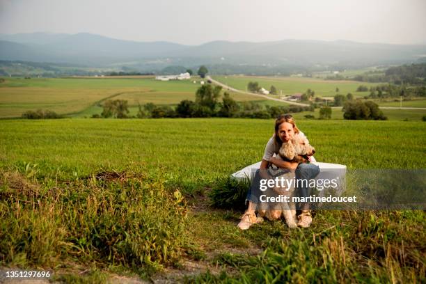 mature woman posing with her dog on the canada-usa border. - eastern townships quebec stock pictures, royalty-free photos & images