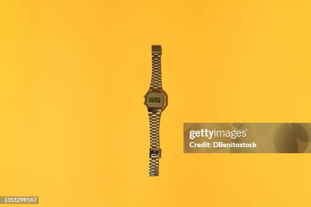 gold digital watch from the 80s with hard shadow on yellow background. time, retro, vintage and 80's concept. - lanière objet manufacturé photos et images de collection