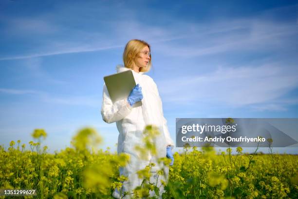 female farm worker making survey on blooming field - agriculture innovation stock-fotos und bilder