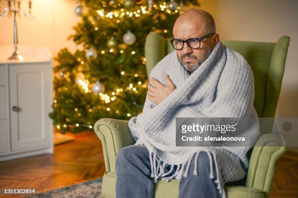 mature adult man in christmas home interior ( in plaid) - frozen man stockfoto's en -beelden
